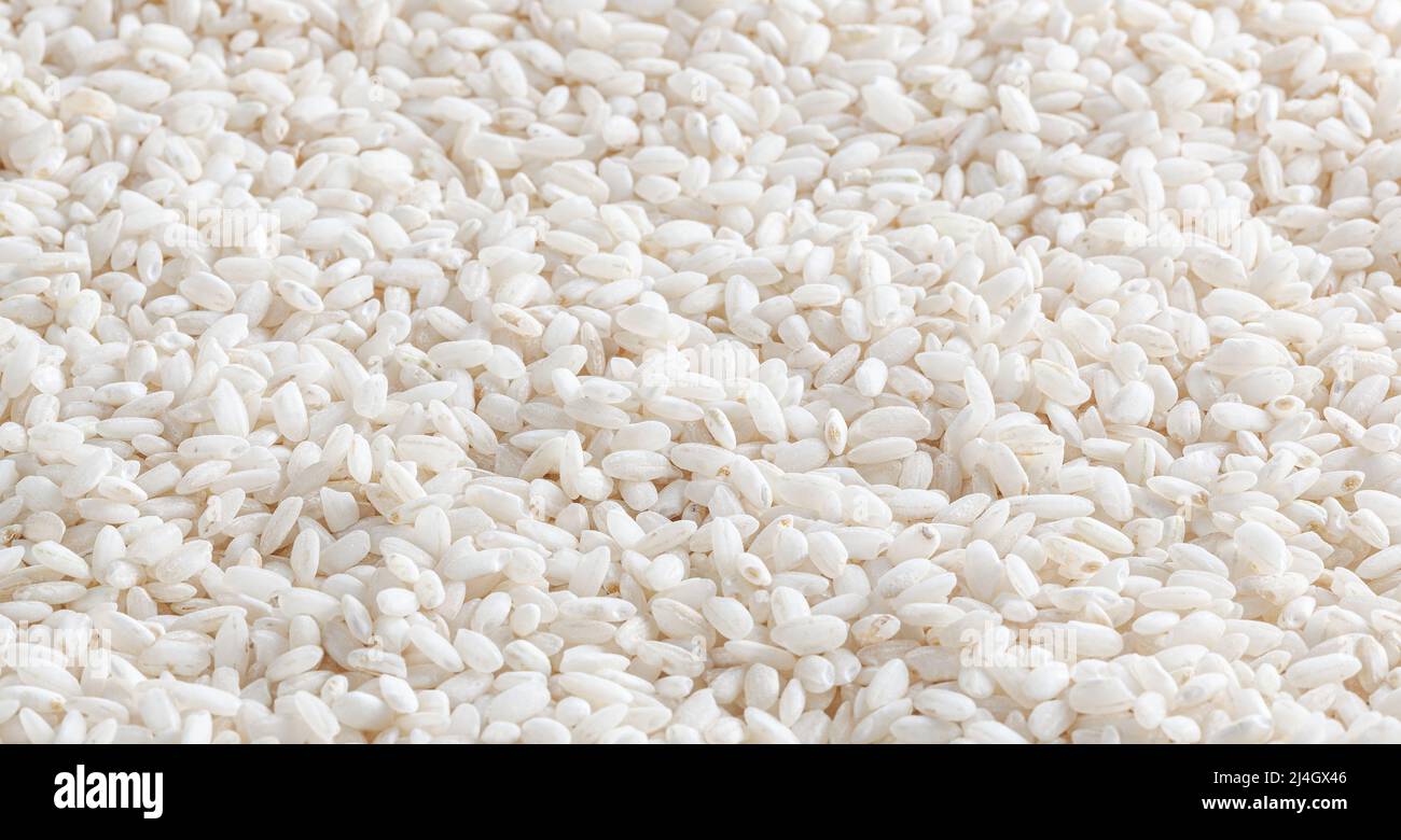 Uncooked arborio rice background Stock Photo Alamy
