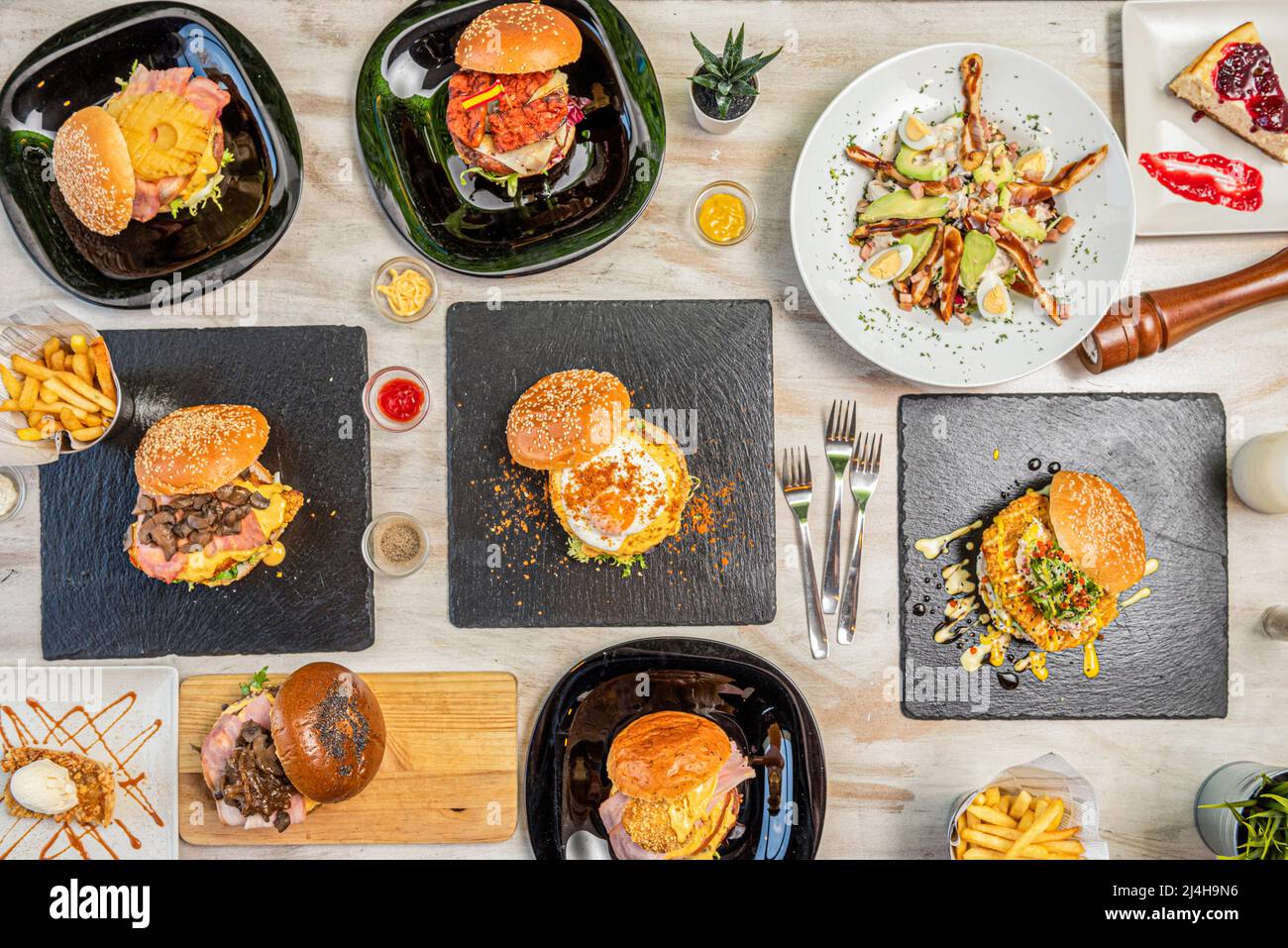 Set of fast food dishes and assorted burgers, salad with eggs, avocado ...