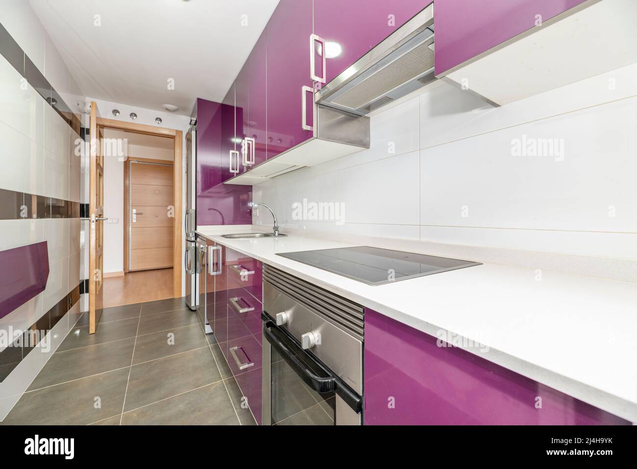 Kitchen with white stone countertops, bright purple wood cabinets