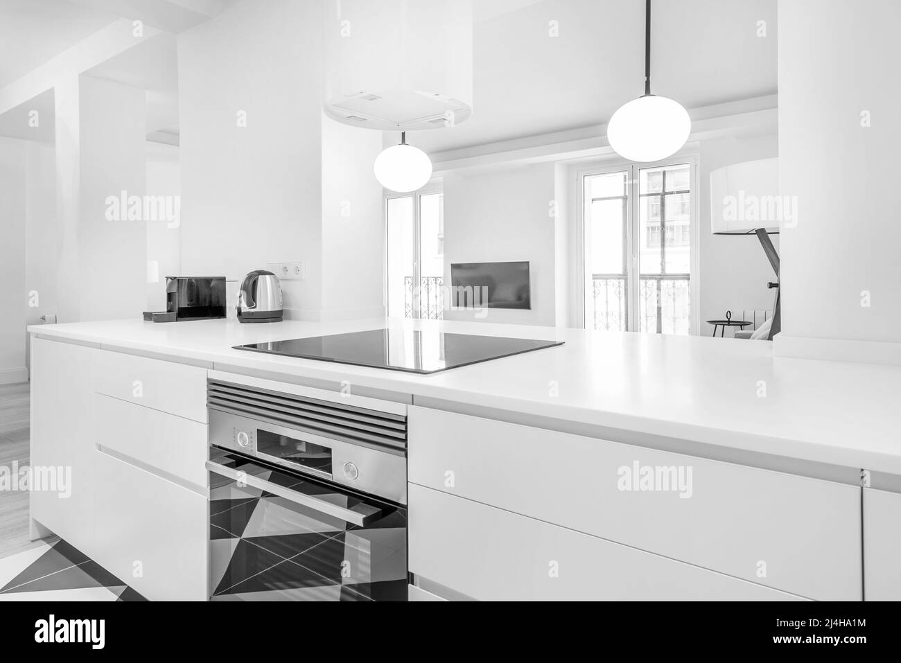 Kitchen with white stone design countertops with dominant white lines and lamps with white spherical lampshades Stock Photo