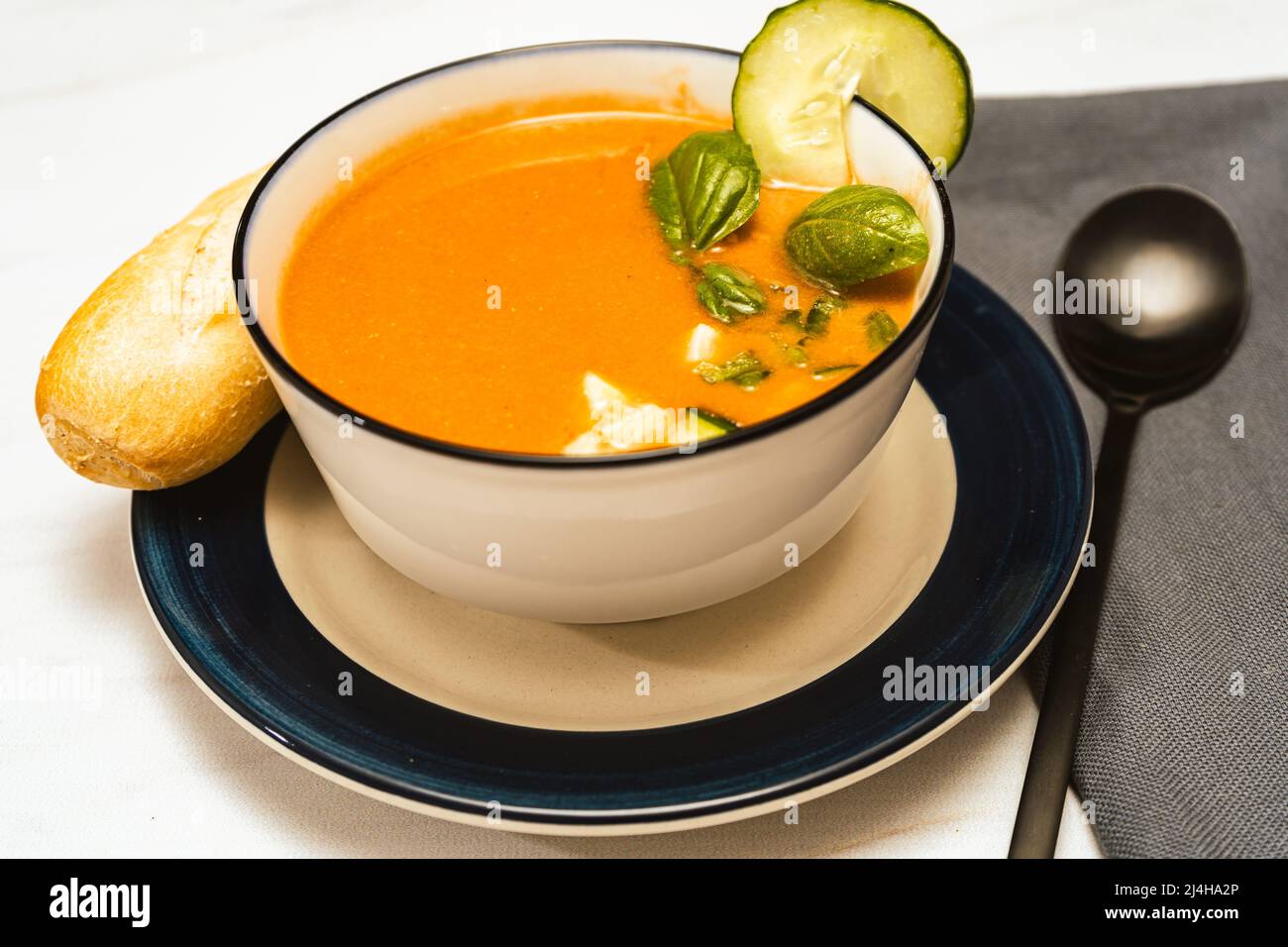 Modern white bowl with Andalusian Gazpacho. Vegetable and organic soup or cold drink that is drunk in summer. Stock Photo