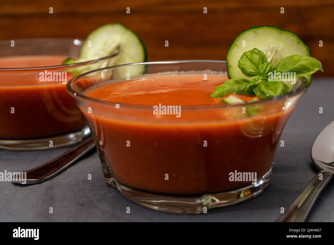 Transparent glass bowl with Gaspacho Andaluz. A vegetable and organic soup or cold drink that is drunk in summer or hot days. Hig view. Close up. Stock Photo