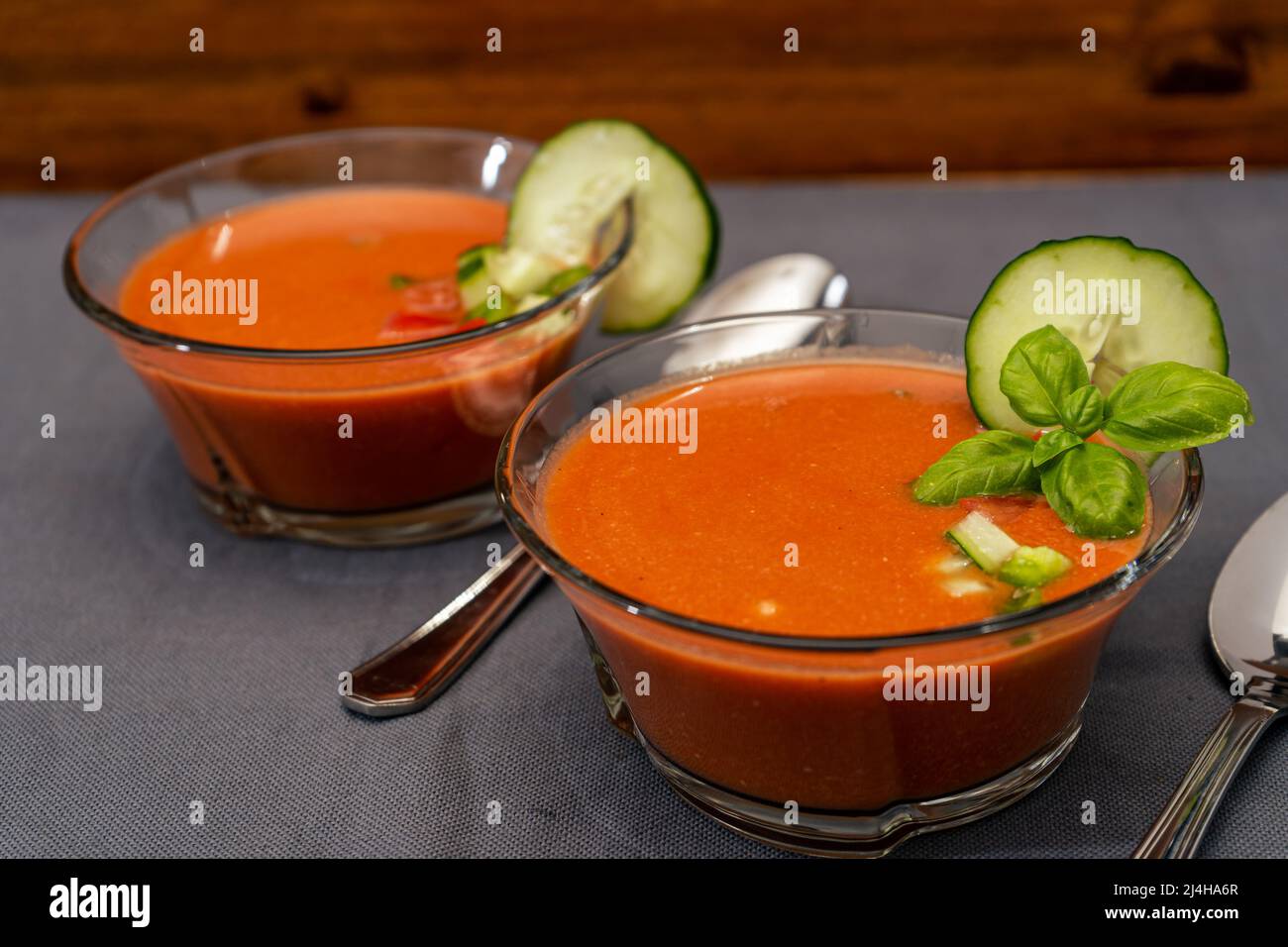 Hig view of tow Transparent glass bowls with Gaspacho Andaluz. A vegetable and organic soup or cold drink that is drunk in summer or hot days. Stock Photo