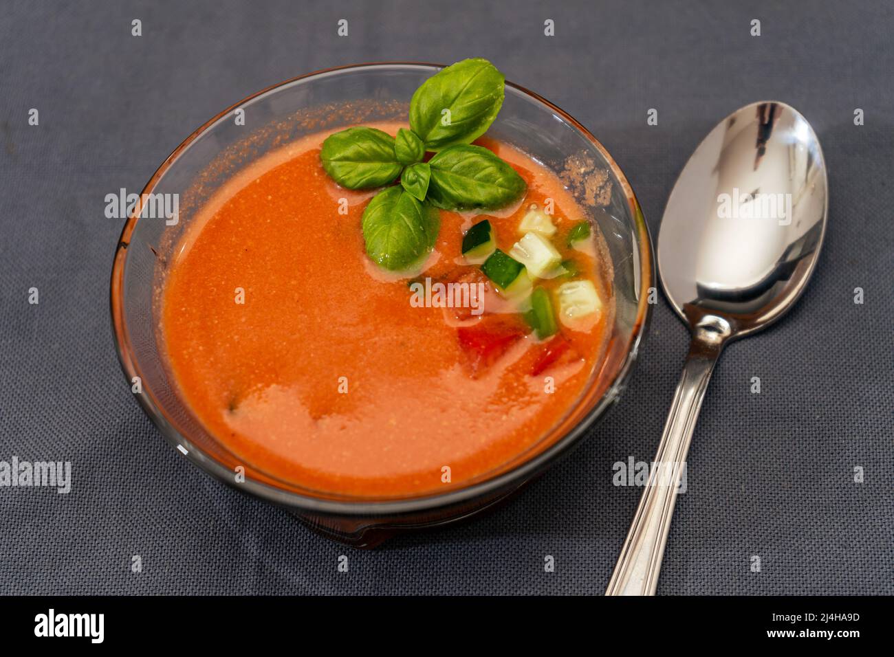 Transparent glass bowl with Gaspacho Andaluz with tomato, cucumber and other vegetables. Organic vegetable soup or cold drink to be drunk in summer or Stock Photo