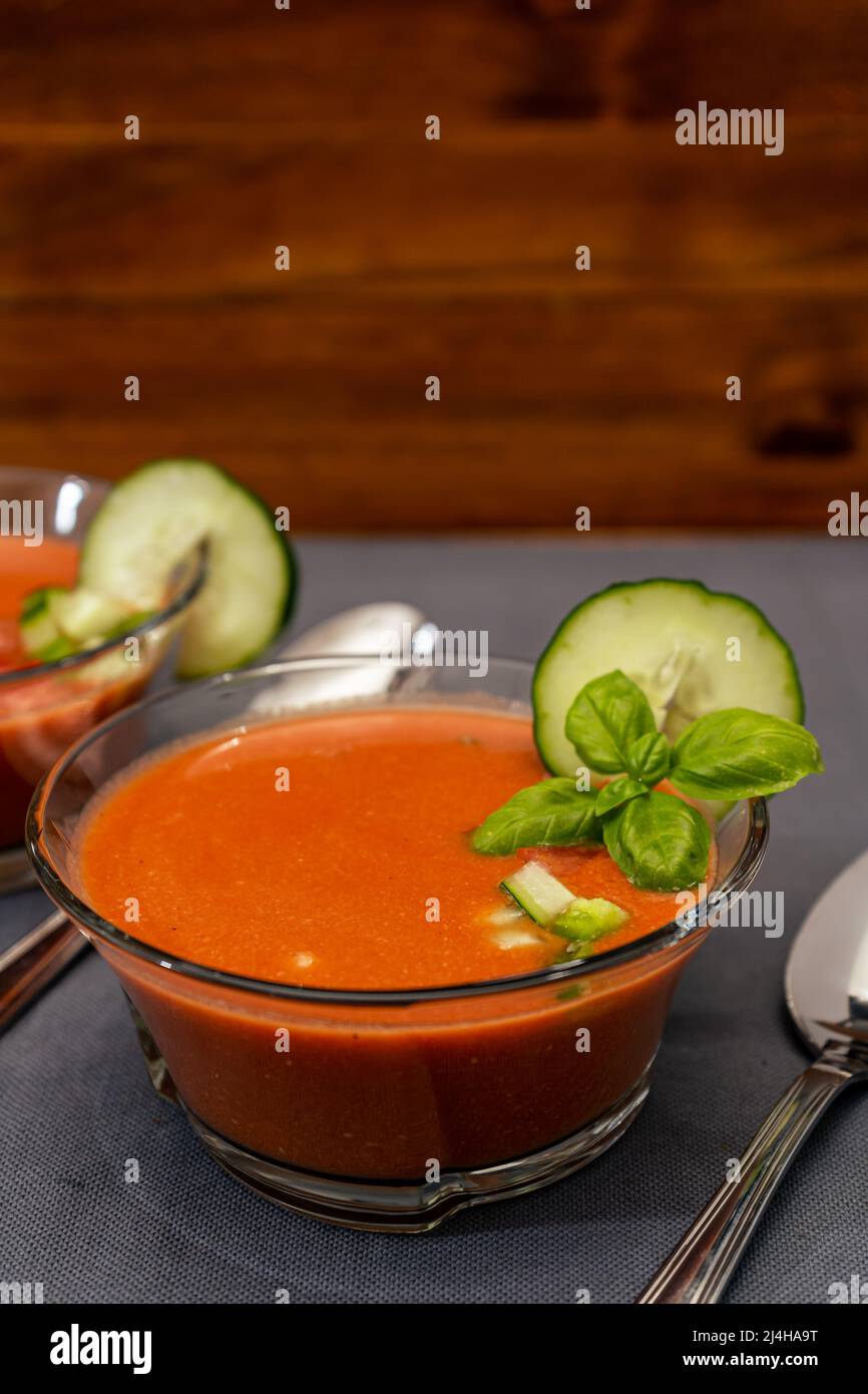 Transparent glass bowl with Gaspacho Andaluz. A vegetable and organic soup or cold drink that is drunk in summer or hot days. Vertical orientation Stock Photo
