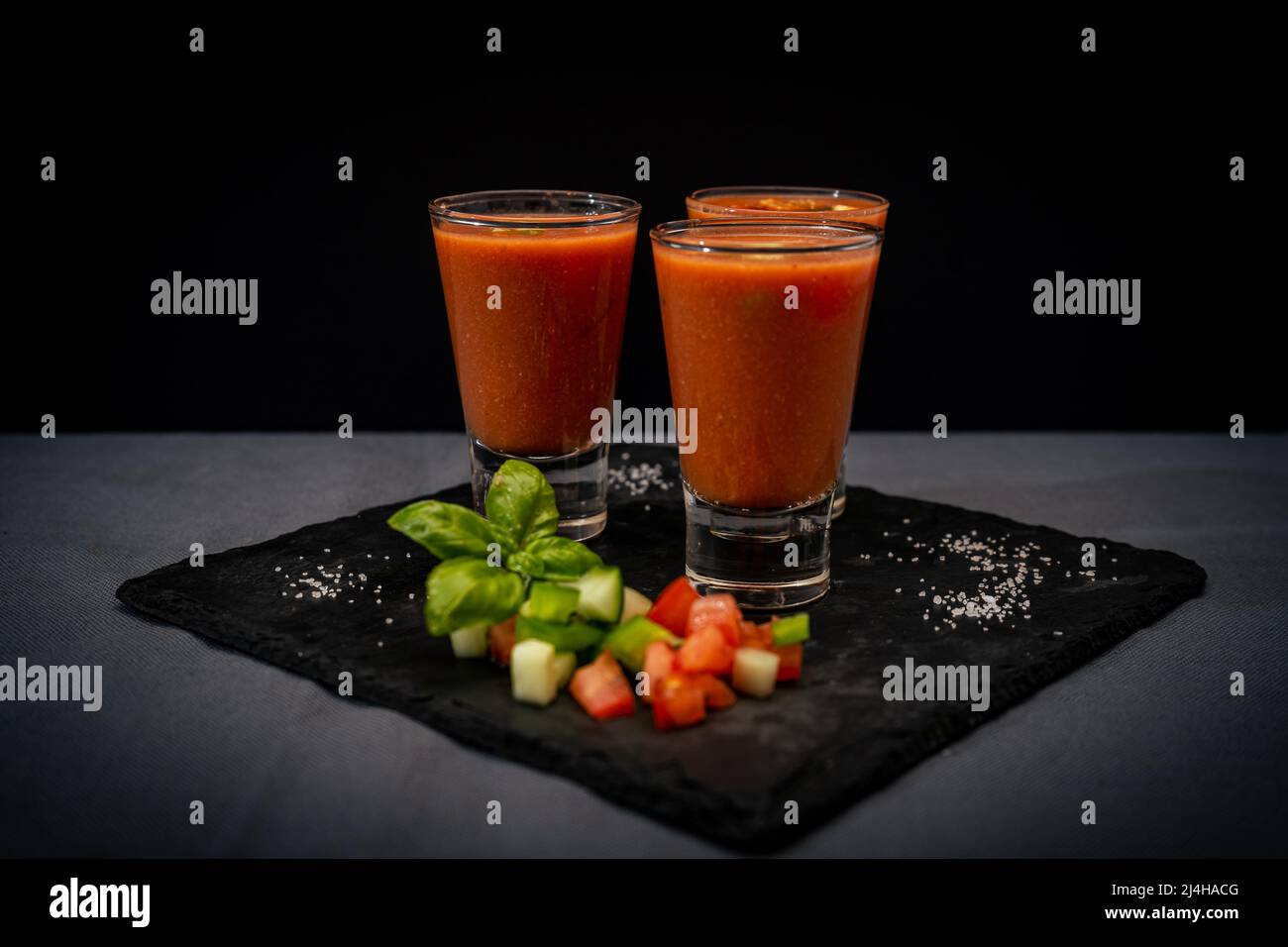 Small glasses of shot or liqueur with Andalusian Gazpacho. A cold vegetable and organic soup or drink that is drunk in summer or hot days. Normal view Stock Photo