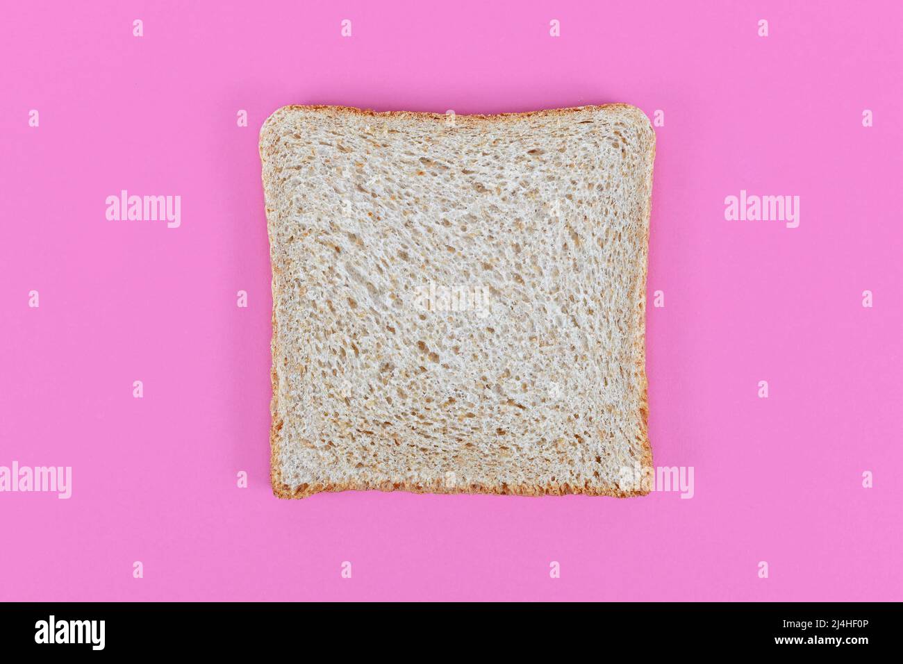 Slices of spelt wheat toast bread on pink background Stock Photo