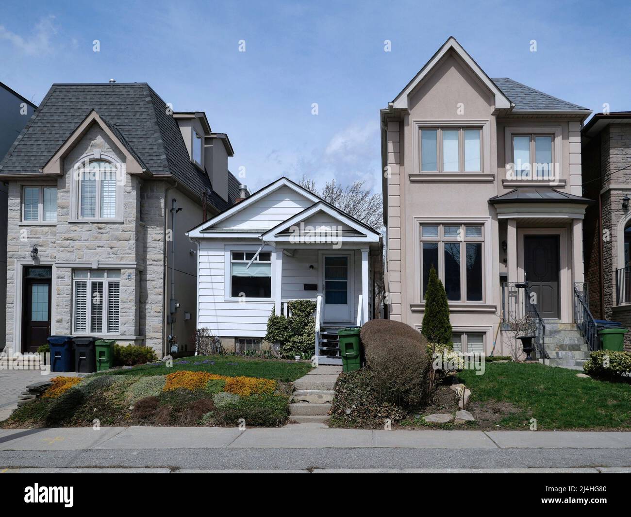 Gentrification in a residential neighborhood, with small homes replaced by larger two story houses Stock Photo