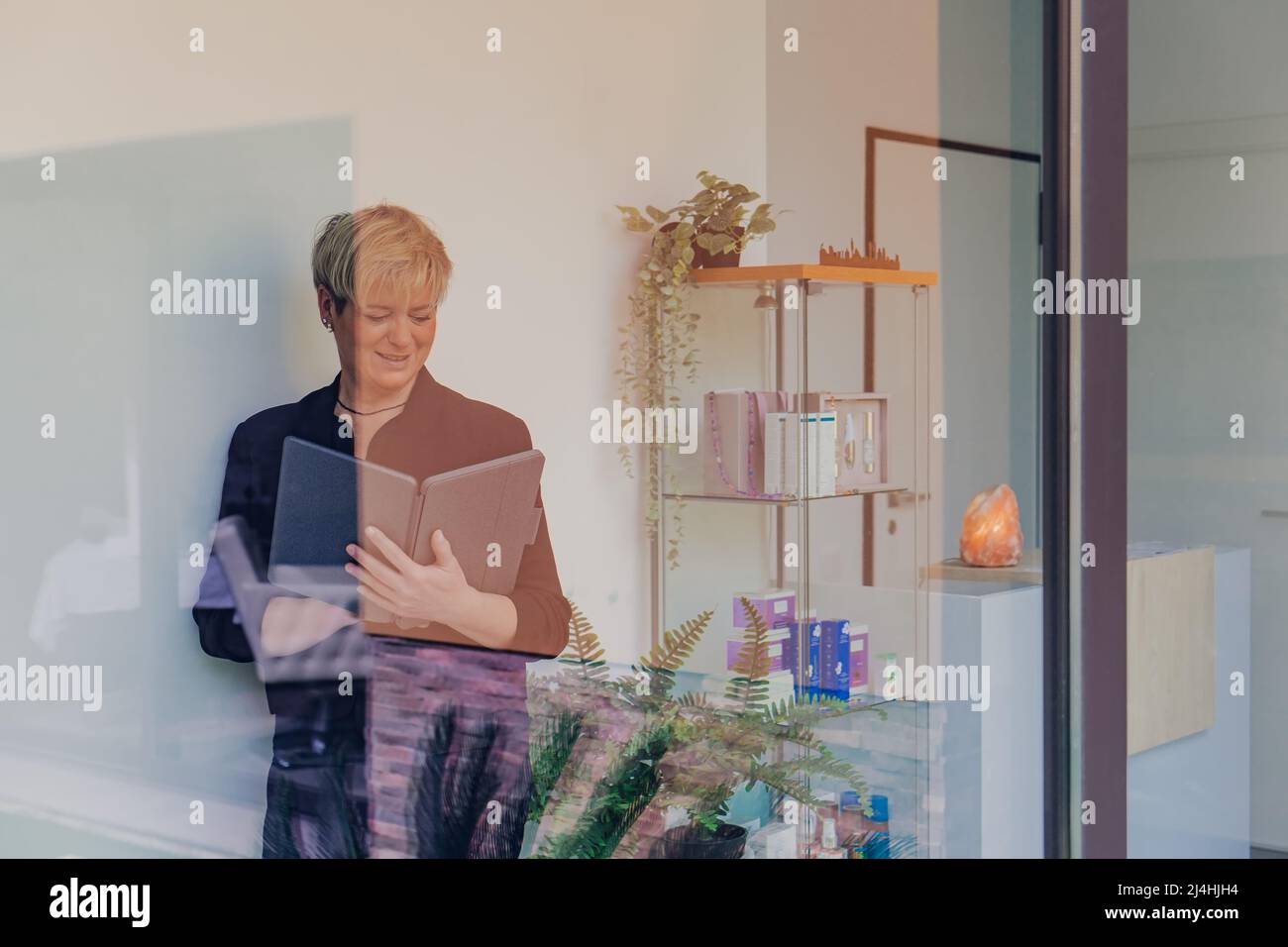 portrait through a window of a business woman checking work tasks on her Tablet. entrepreneurial woman. Stock Photo