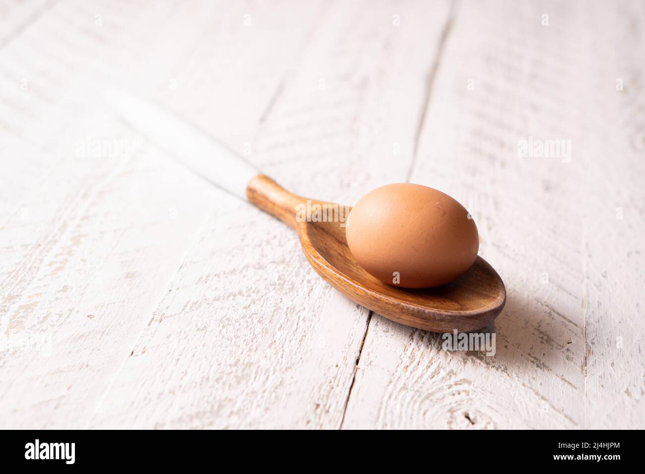 brown-chicken-egg-and-a-wood-spoon-stock-photo-alamy