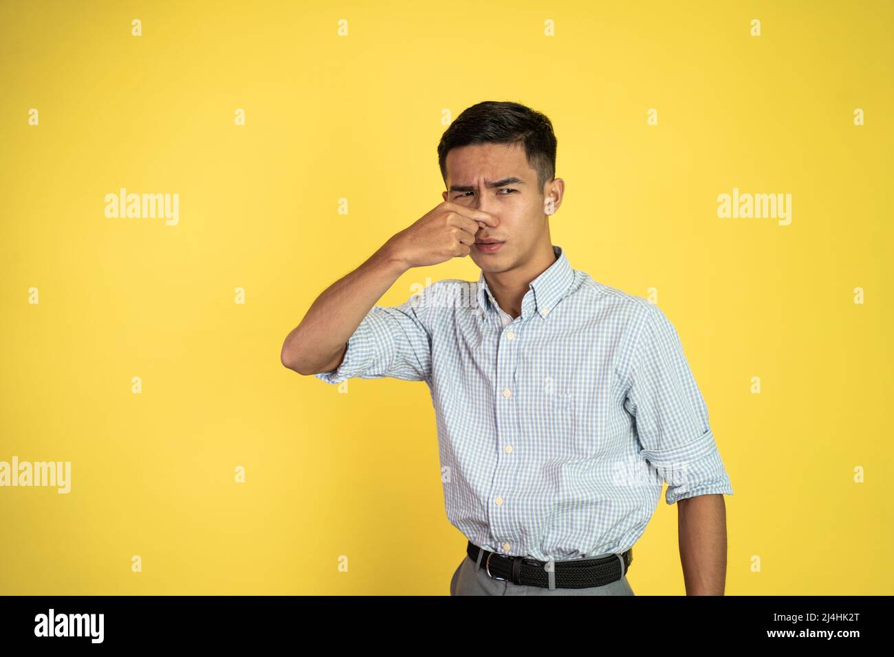 man cover his nose and feeling disgusted by the smell Stock Photo