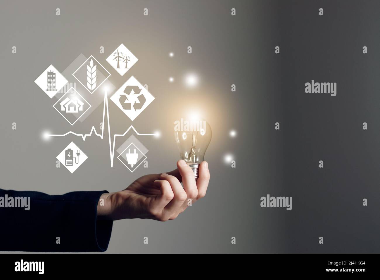 Woman hand holding light bulb with icons energy sources for renewable ...