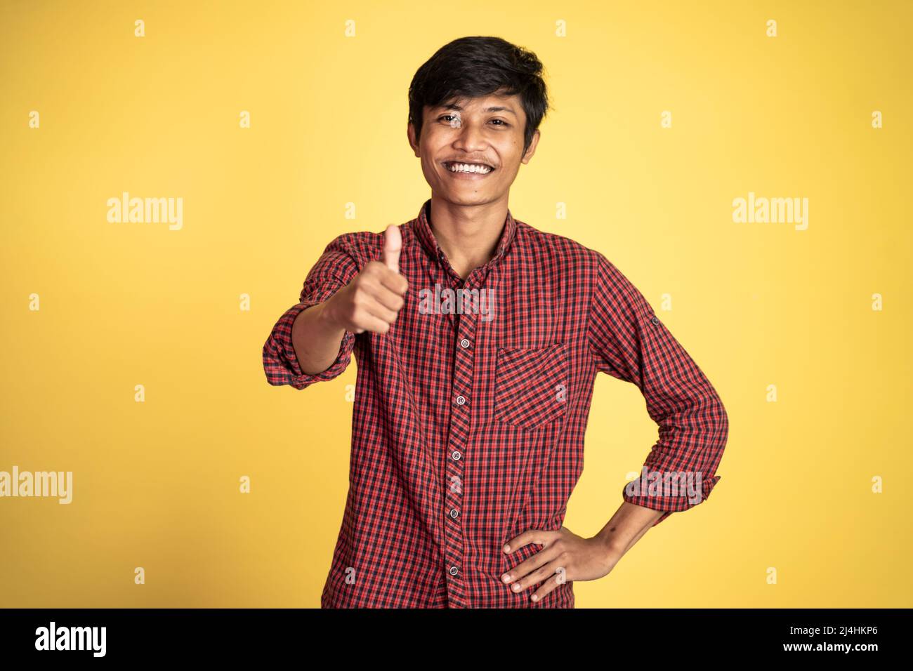 asian young man showing thumbs up with smiling teeth Stock Photo - Alamy