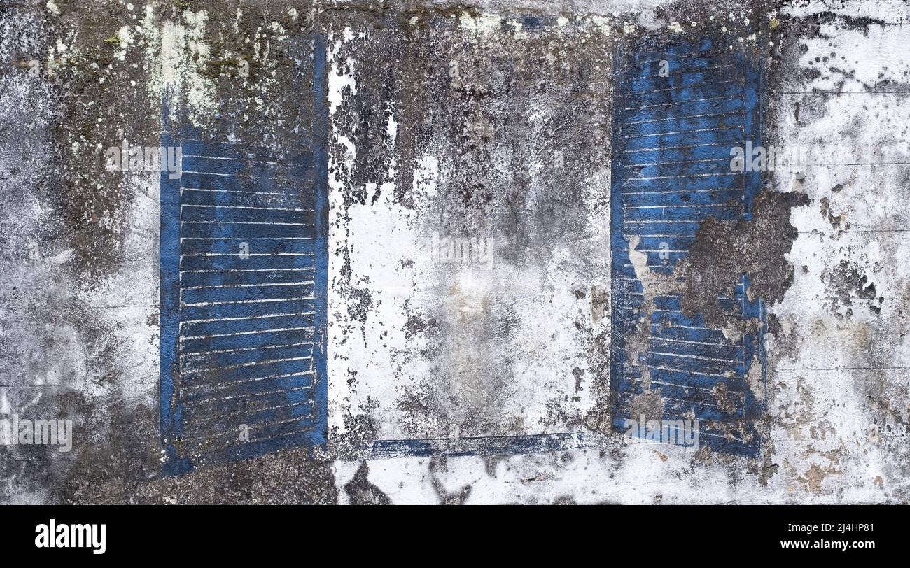 Distressed white and gray peeling paint cement wall with open position blue shutters. Space for copy Stock Photo