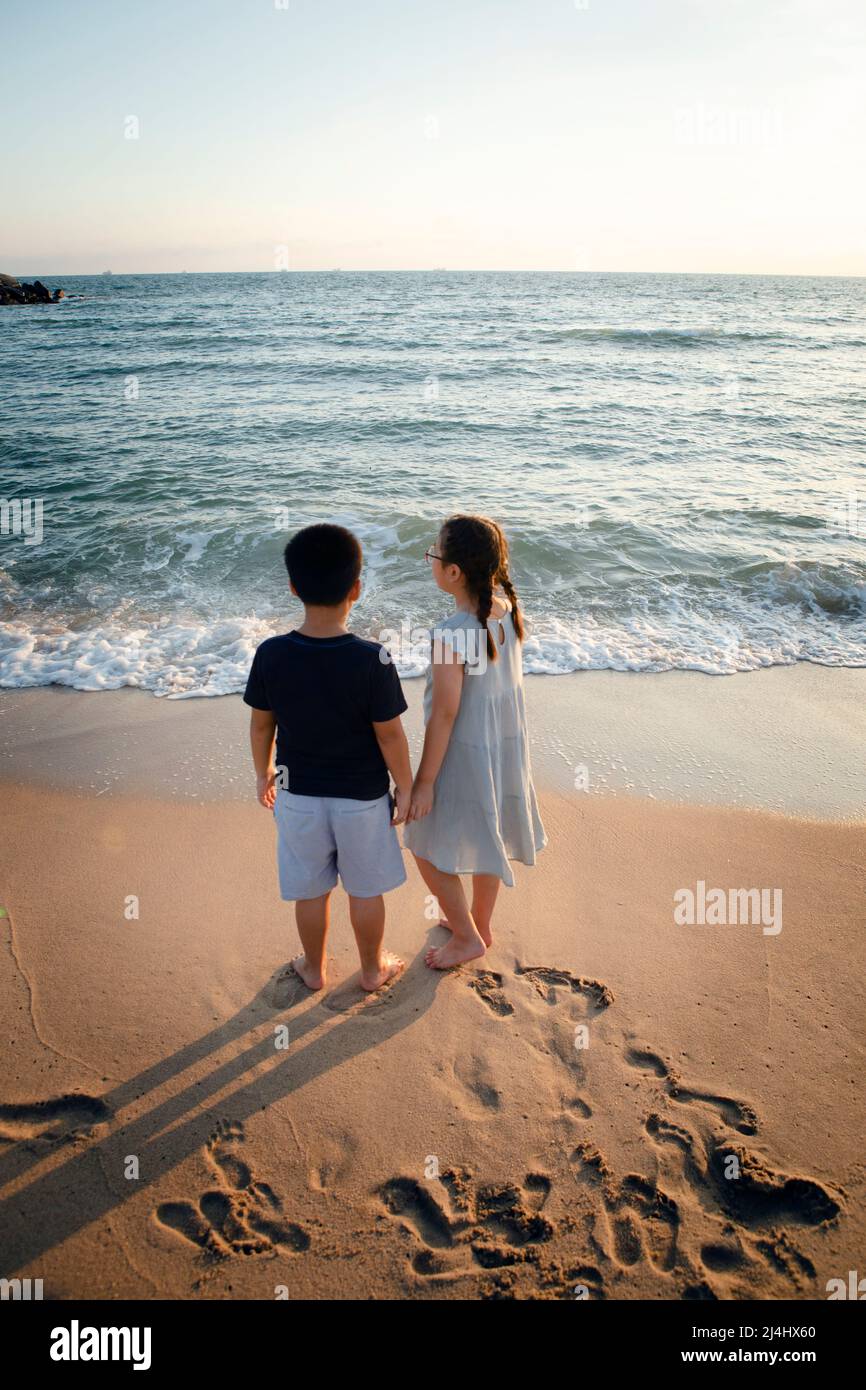 couples of asian children standing at seaside Stock Photo