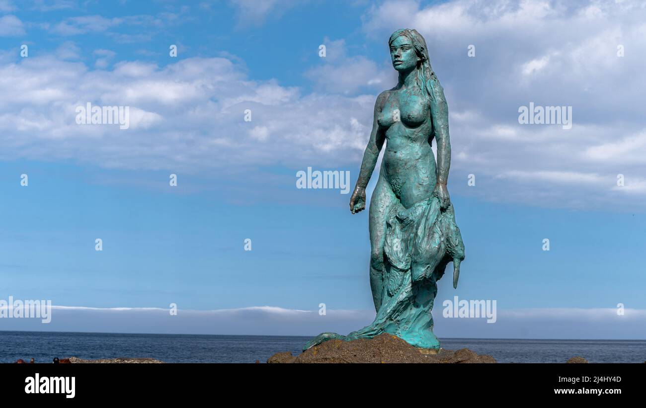 View of the statue of the Seal Woman - Kópakonan, the village, waterfall in the Faroe Islands in the island of Kalsoy Stock Photo