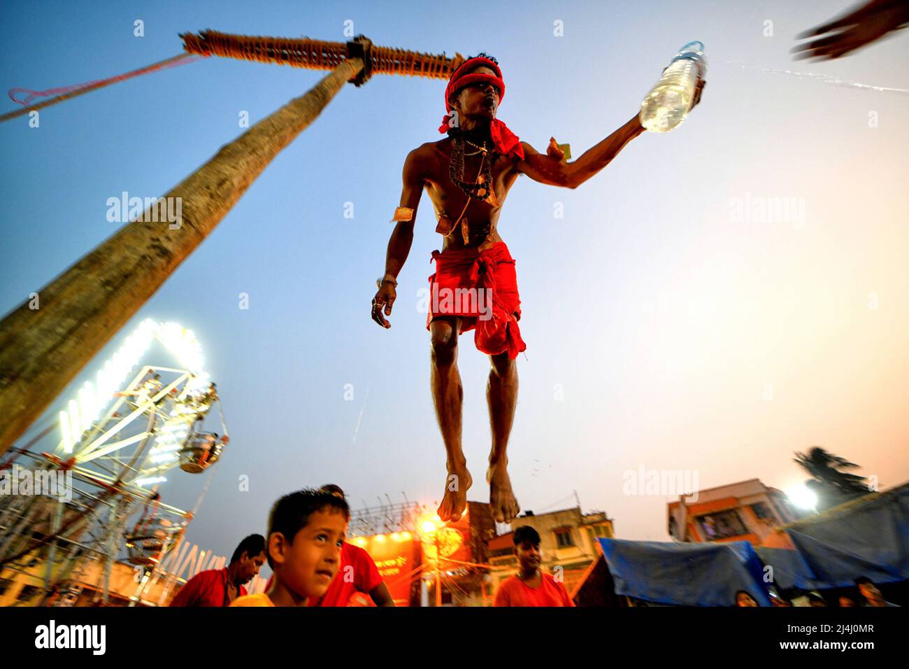 Kolkata, India. 15th Apr, 2022. A Hindu devotee seen hanging with a hook during Charak Puja