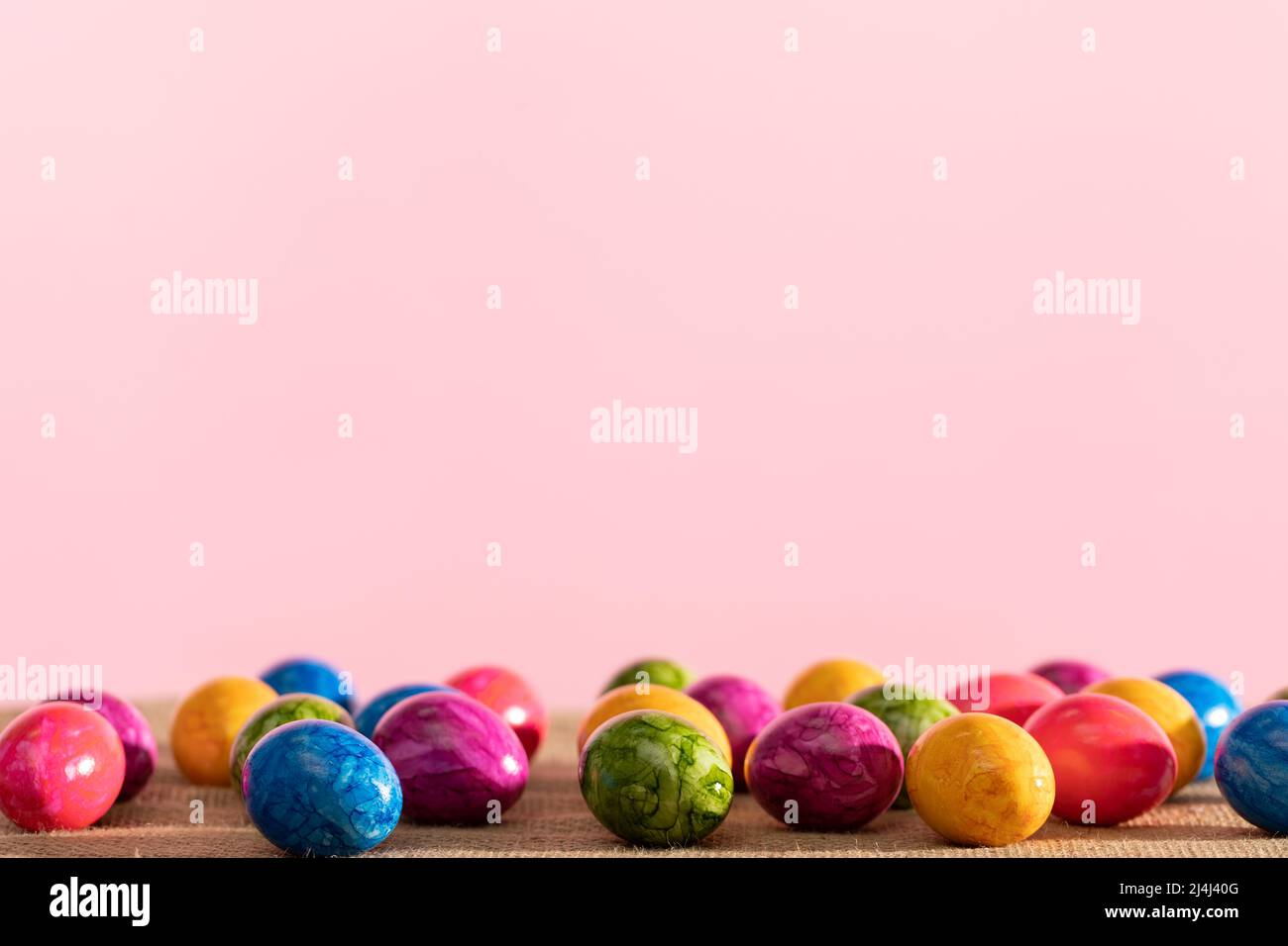 Scattered colored chicken eggs on linen fabric. Easter. Stock Photo