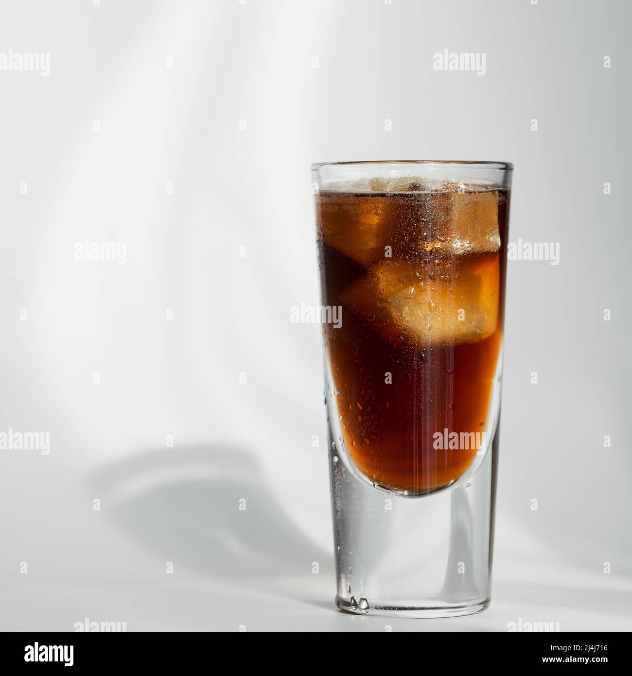 Glass of cola with ice on a white background Stock Photo - Alamy