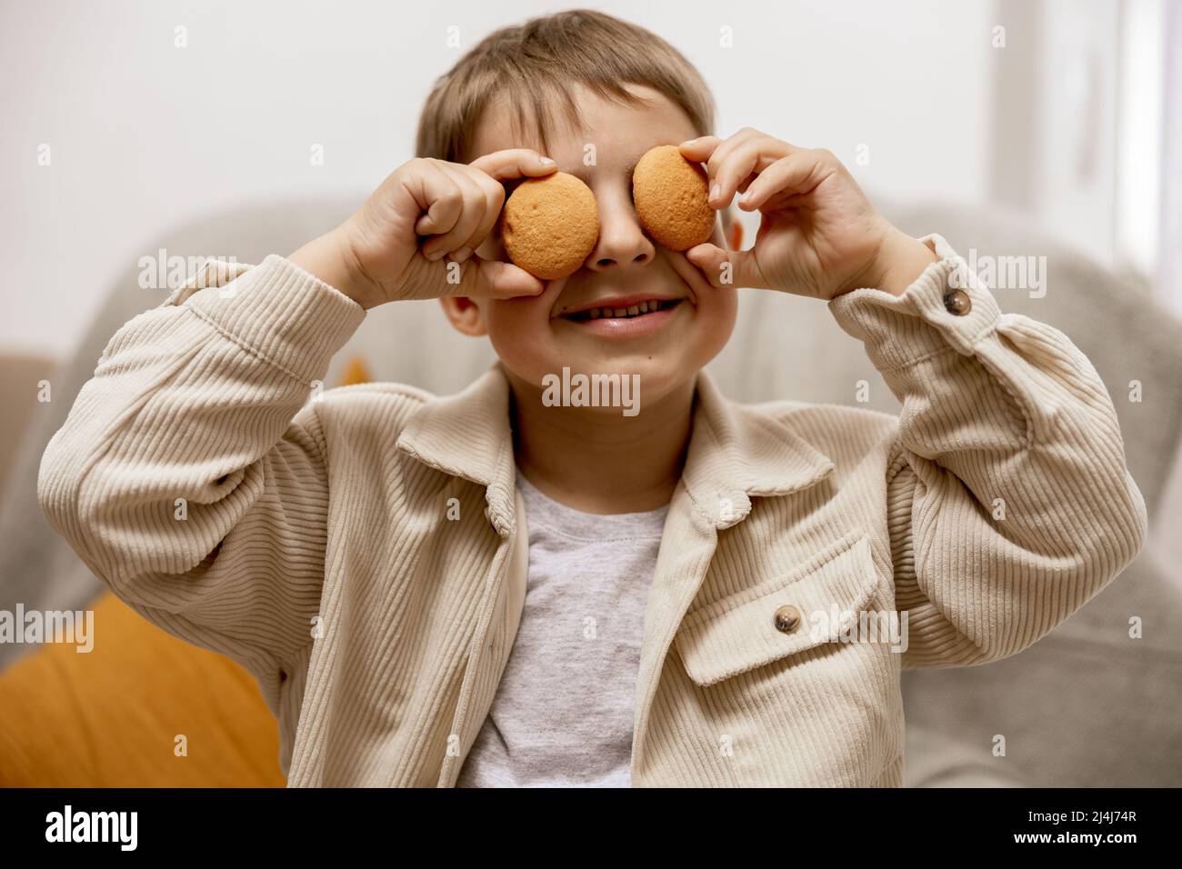 Portrait of little adorable boy holding two biscuits. Kid with cookies. Child and gluten. Healthcare, gluten intolerance by kids. Preschool child with Stock Photo