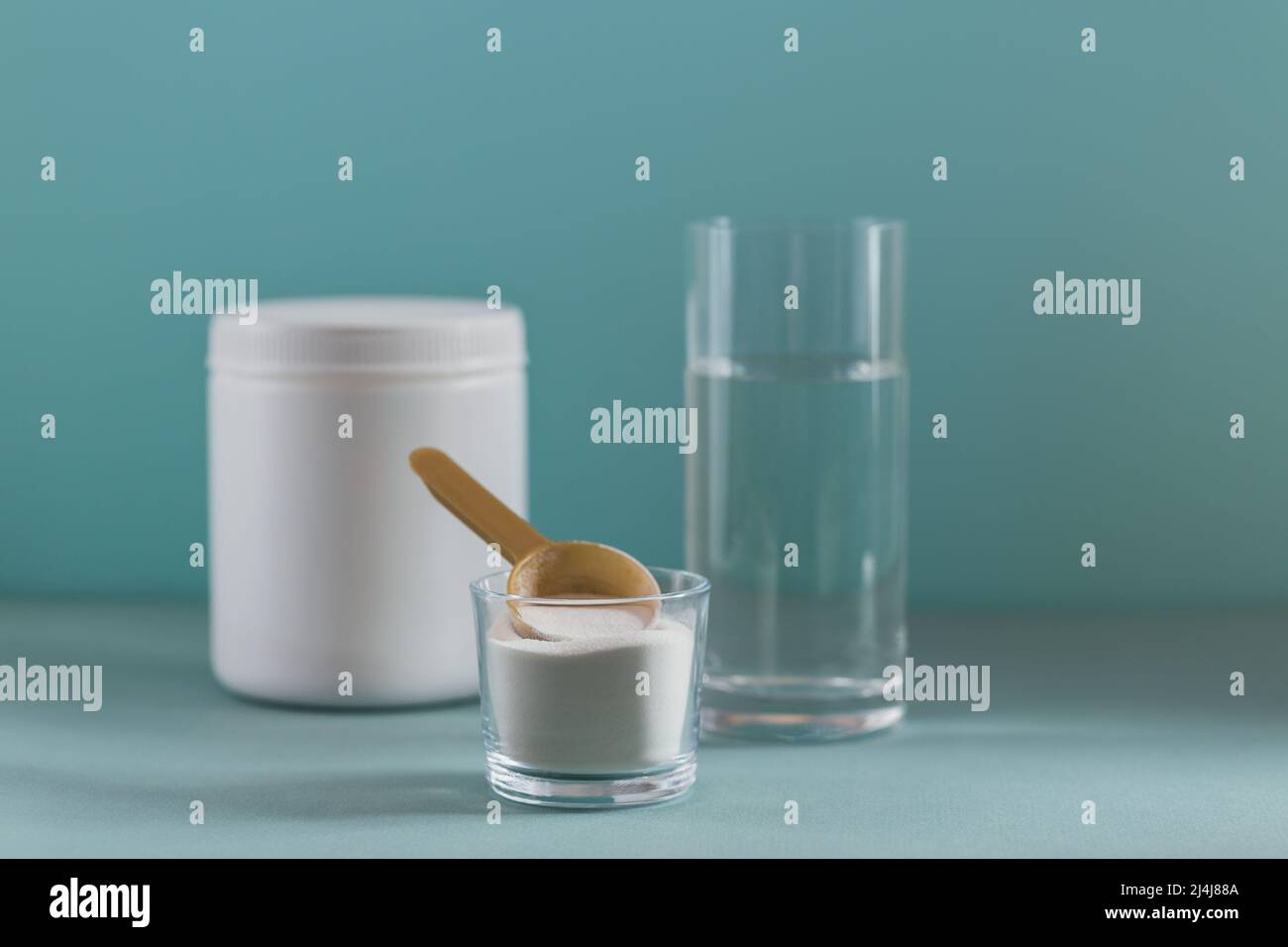 Glass with collagen dissolved in water and collagen protein powder on