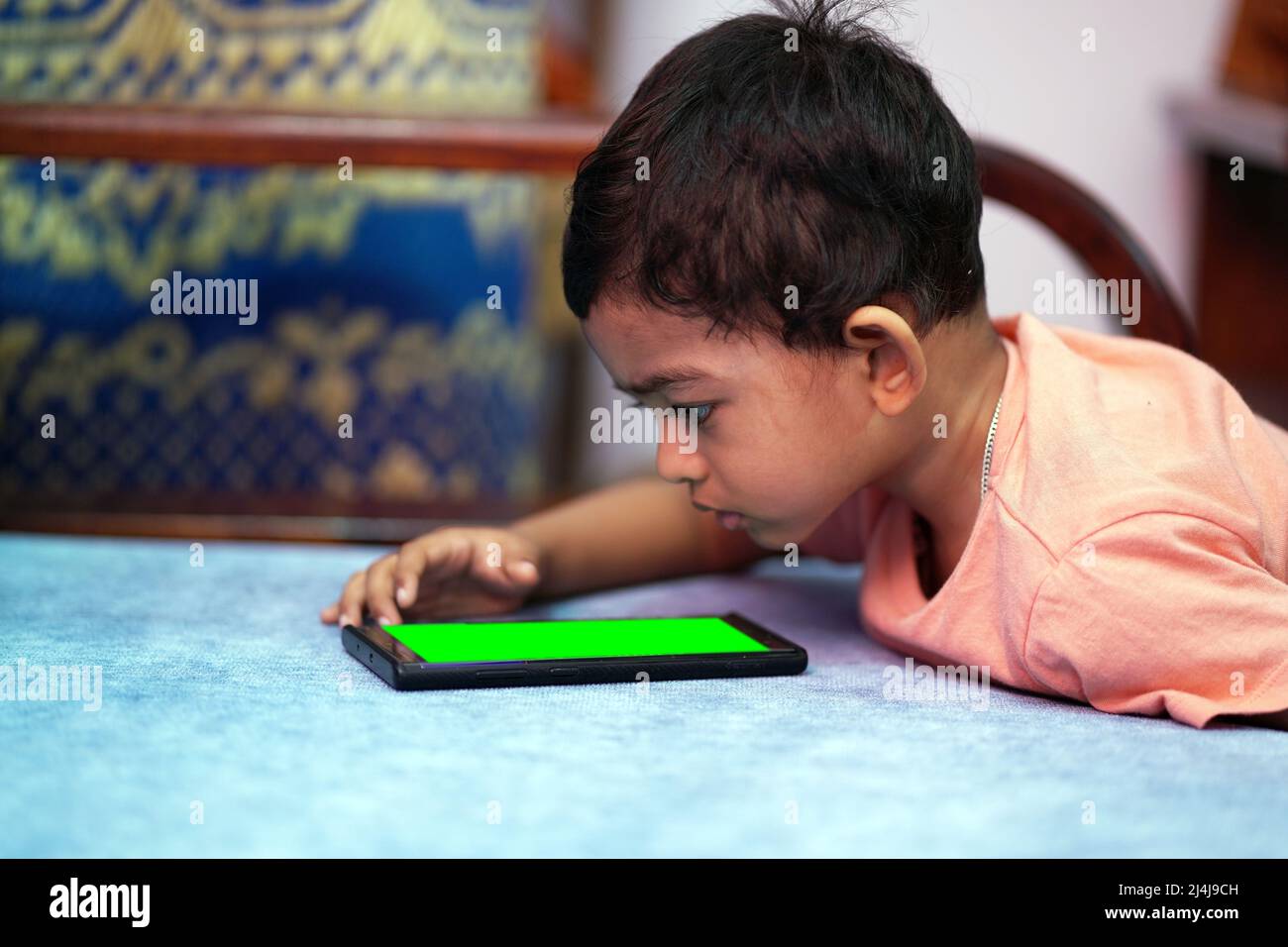 a toddler baby boy engaged in watching and exploring mobile phone