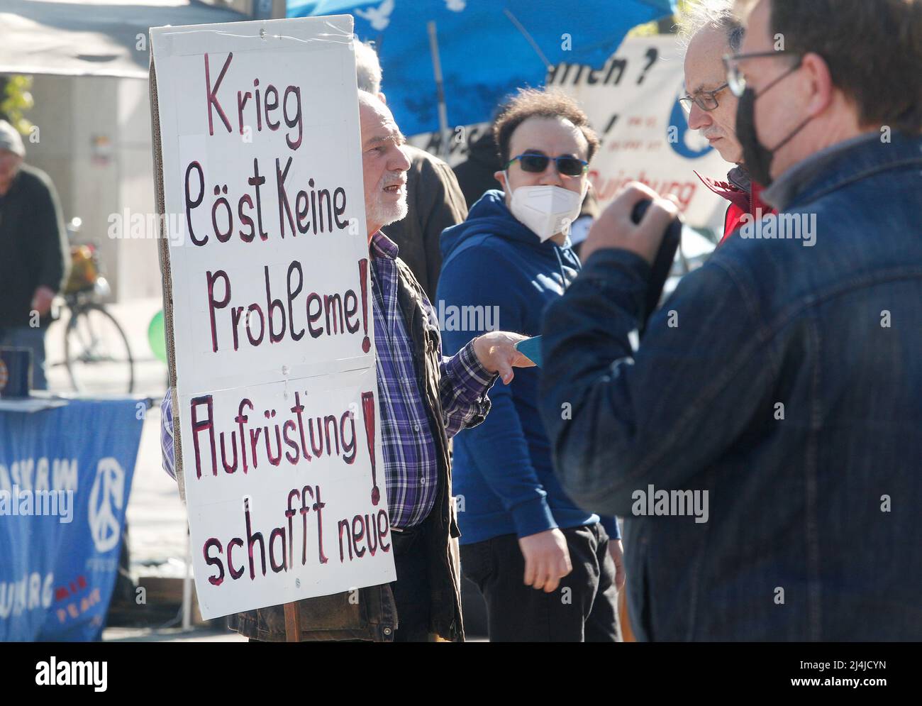 16 April 2022, North Rhine-Westphalia, Duisburg: At the start of the Easter March Rhine/Ruhr, a participant demands on a poster 'War solves no problems! Rearmament creates new ones'. Photo: Roland Weihrauch/dpa Stock Photo