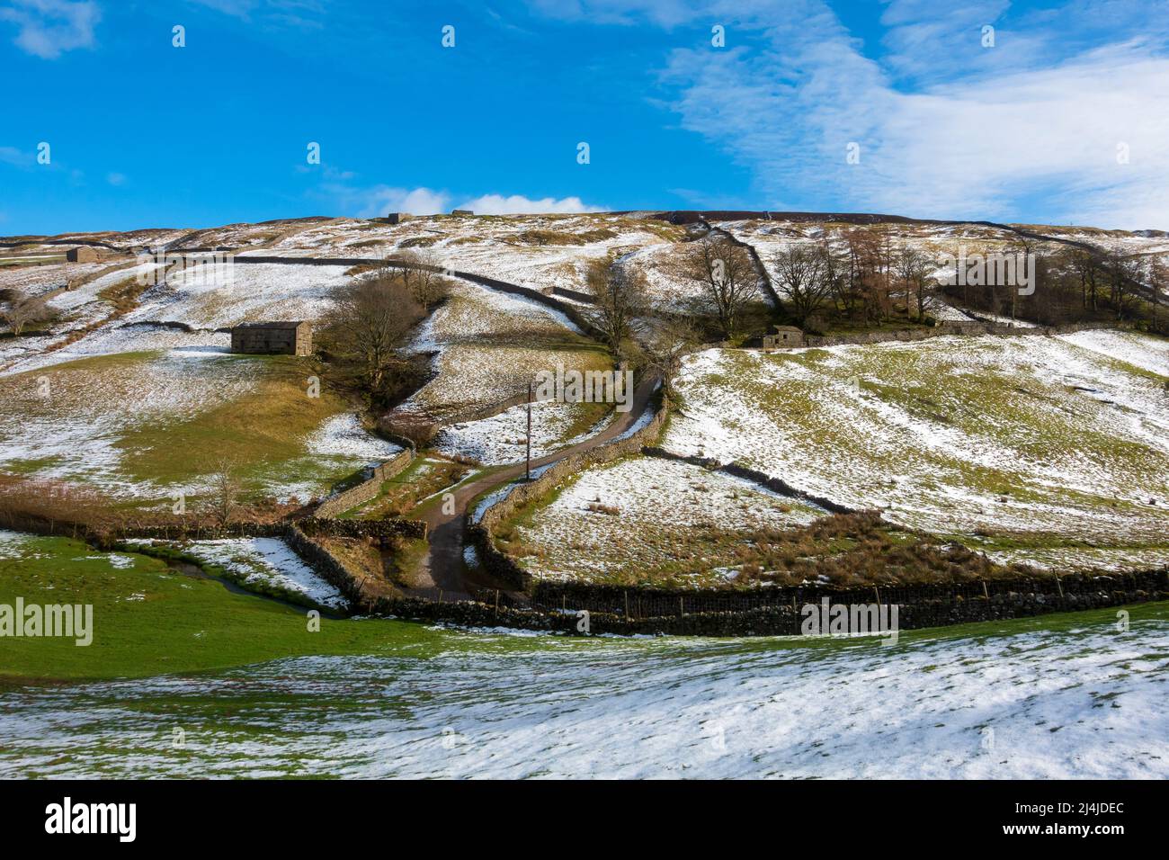 Stone barns and snow covered hills in Swaledale, Yorkshire Dales National Park. Stock Photo