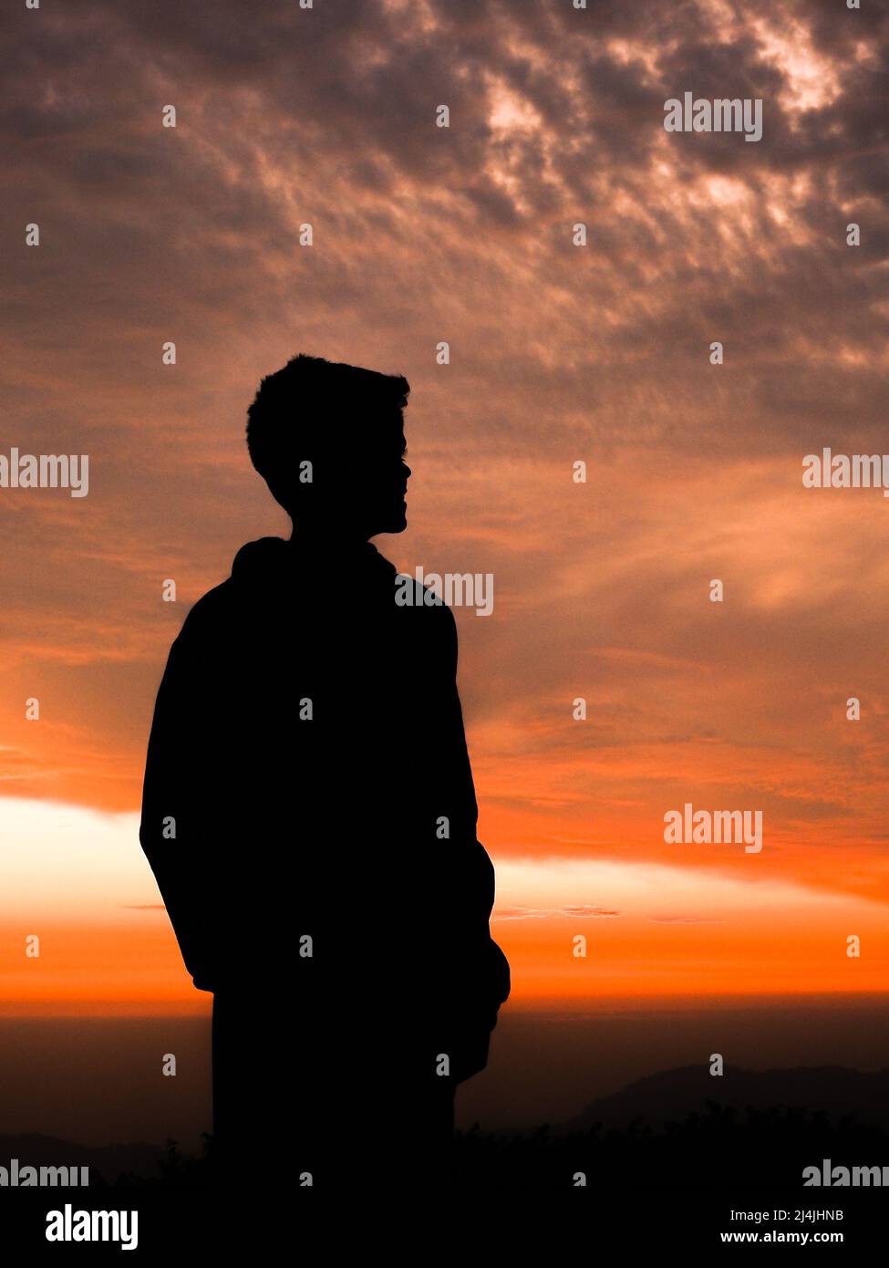 A silhouette of a man standing against an evening sky Stock Photo - Alamy