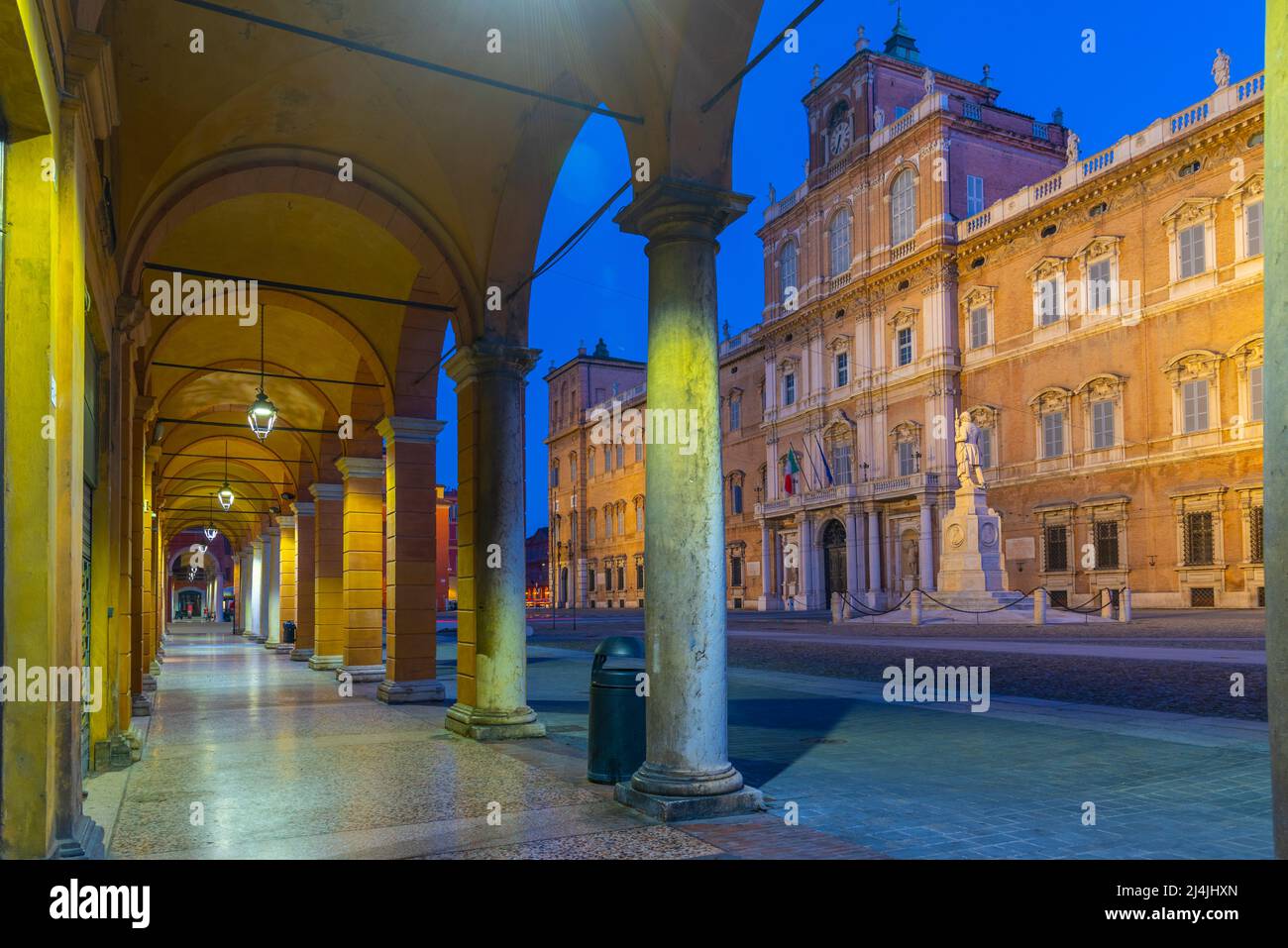 Sunrise view of Palazzo Ducale through an arcade in Italian town Modena. Stock Photo