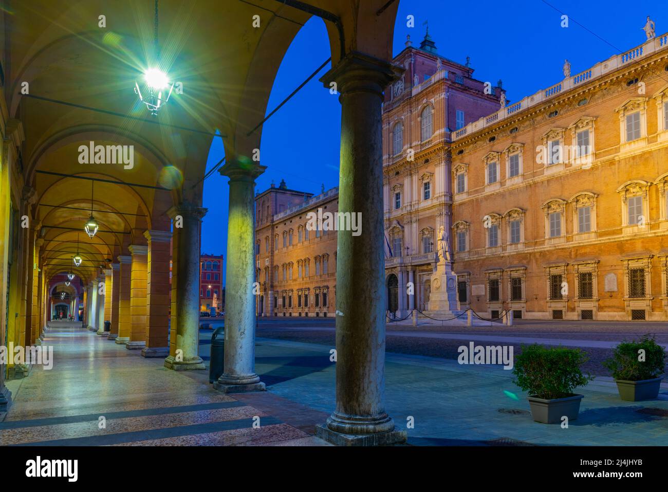 Sunrise view of Palazzo Ducale through an arcade in Italian town Modena. Stock Photo