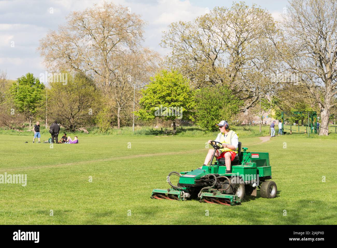 A groundsman mowing the grass on Putney Common using a Ransomes Highway Cylinder Mower Stock Photo
