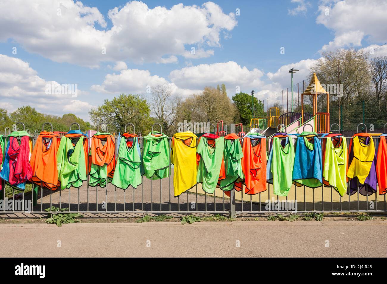 Colourful children's sports vests and singlets airing in the sun at Rocks Lane Multi Sports Centre Stock Photo