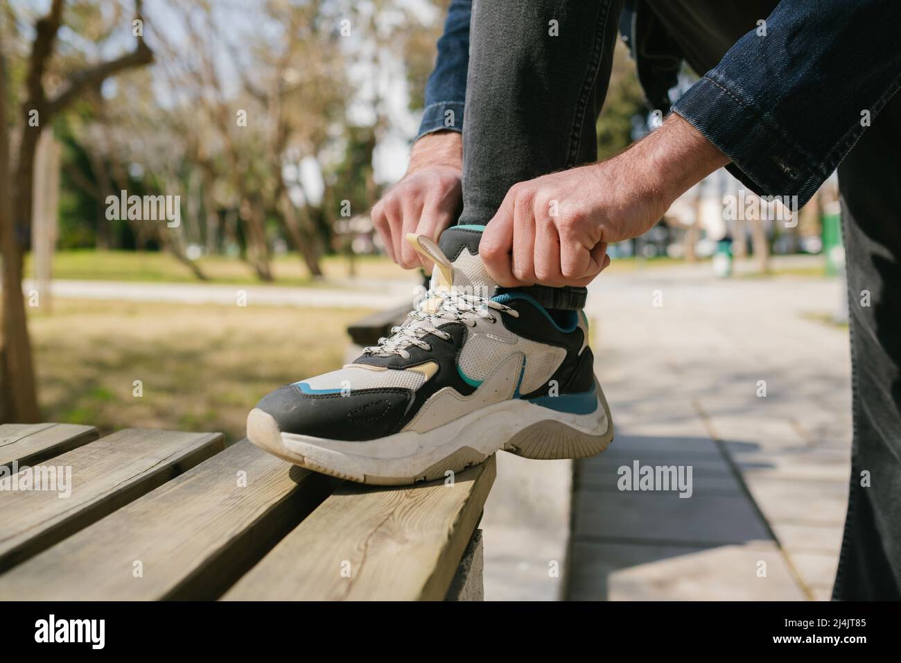 Close up walking man stand step on the footpath trying shoelace shoes  getting ready for walking tour Stock Photo - Alamy