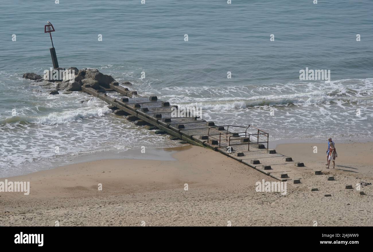 People walk along Boscombe beach as the UK is set for another day of warm weather ahead of Easter Sunday, after experiencing the hottest day of the year so far. Picture date: Saturday April 16, 2022. Stock Photo