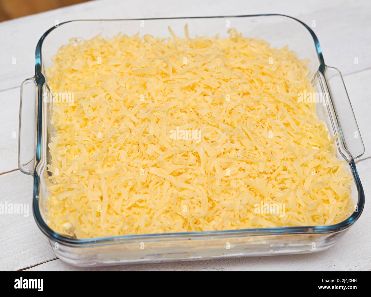 Top view of uncooked lasagna in transparent tray on a wooden background Stock Photo