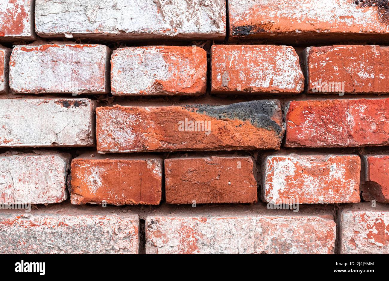 Brick wall with weathered paint, close-up texture background Stock Photo