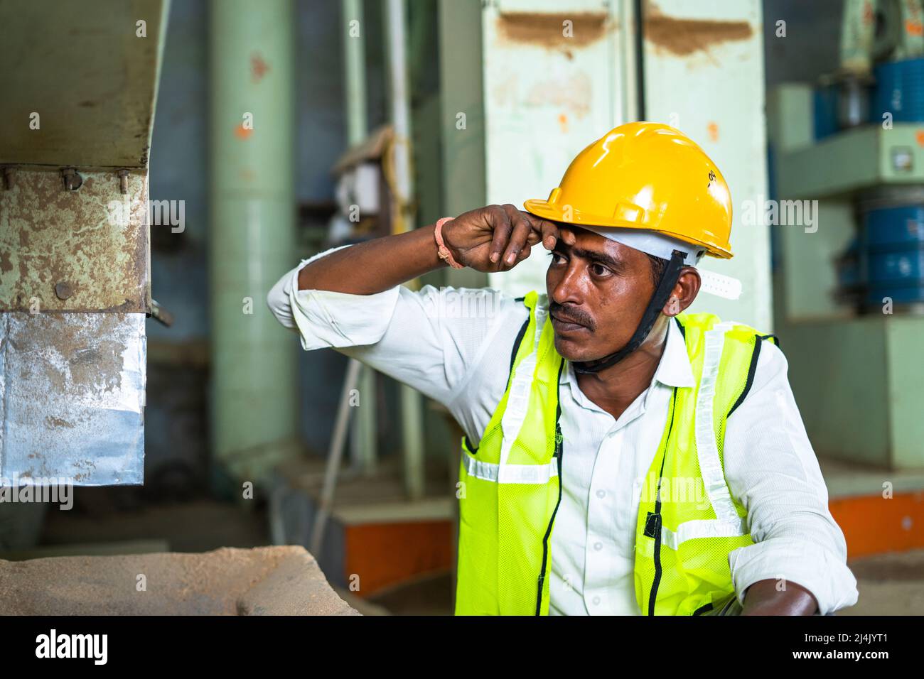 Industrial worker busy working in front of machine - concept of manual labour, hardworking and blue collar jobs Stock Photo