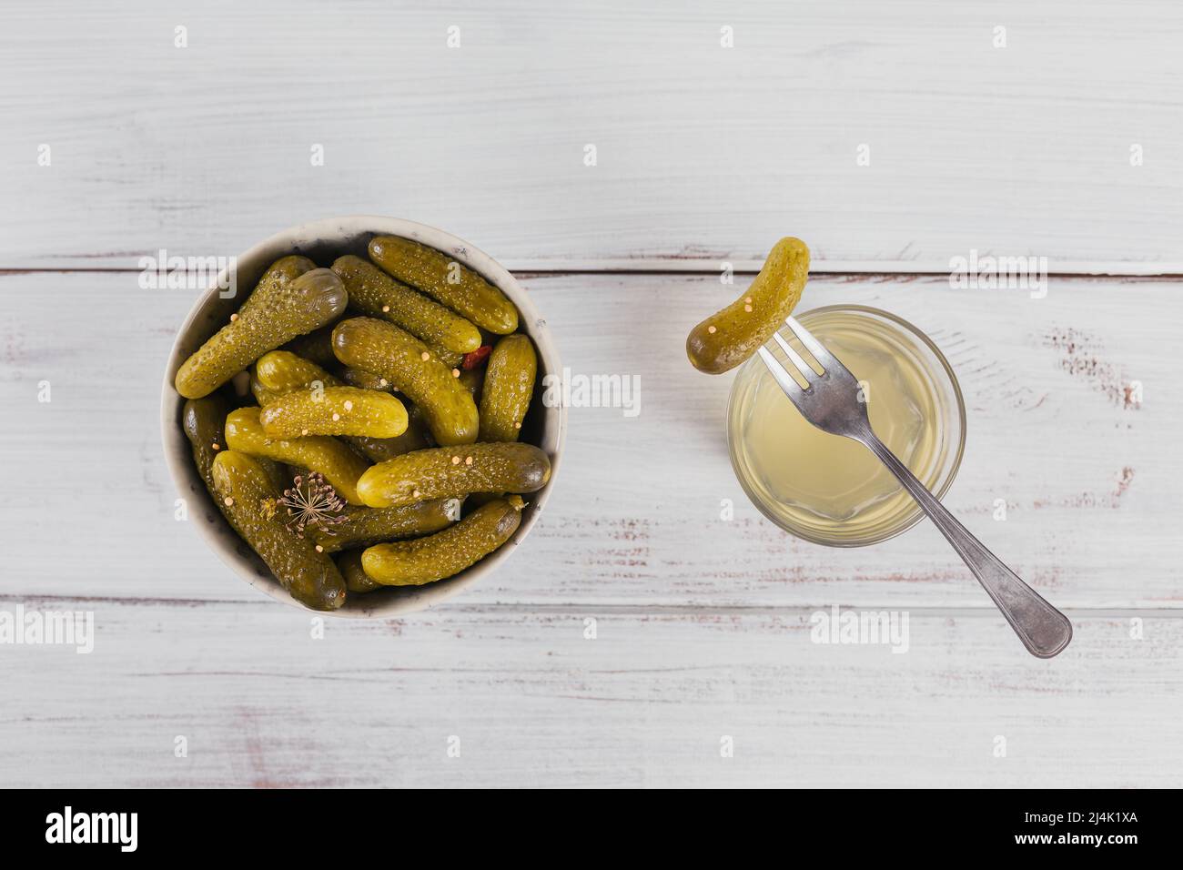 Pickled juice, pickle and marinated cucumber in bowl. Clean eating, vegetarian food concept Stock Photo