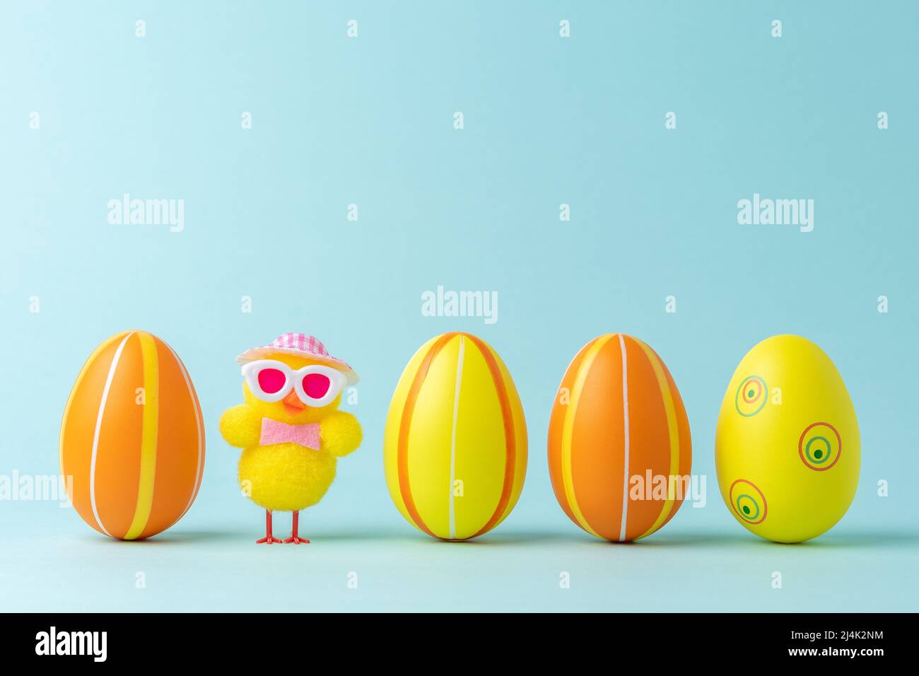 Colorful easter eggs with chicken on pastel blue background. Easter minimal concept. Creative Happy Easter or spring layout. Stock Photo