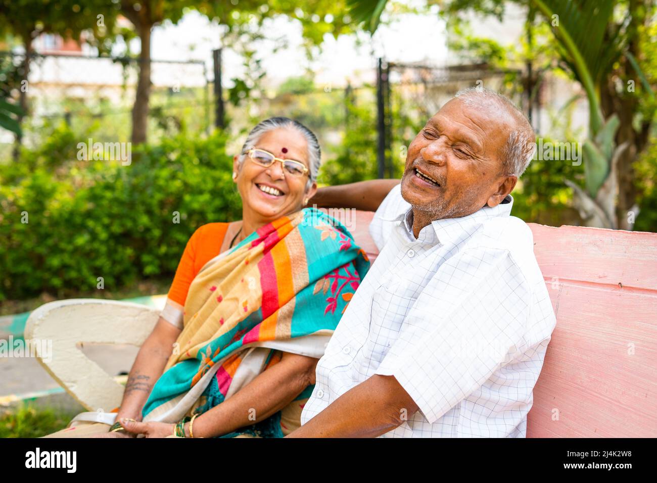 laughing Senior couple while talking with each other at park - concept of friendship, enjoyment and relaxation Stock Photo