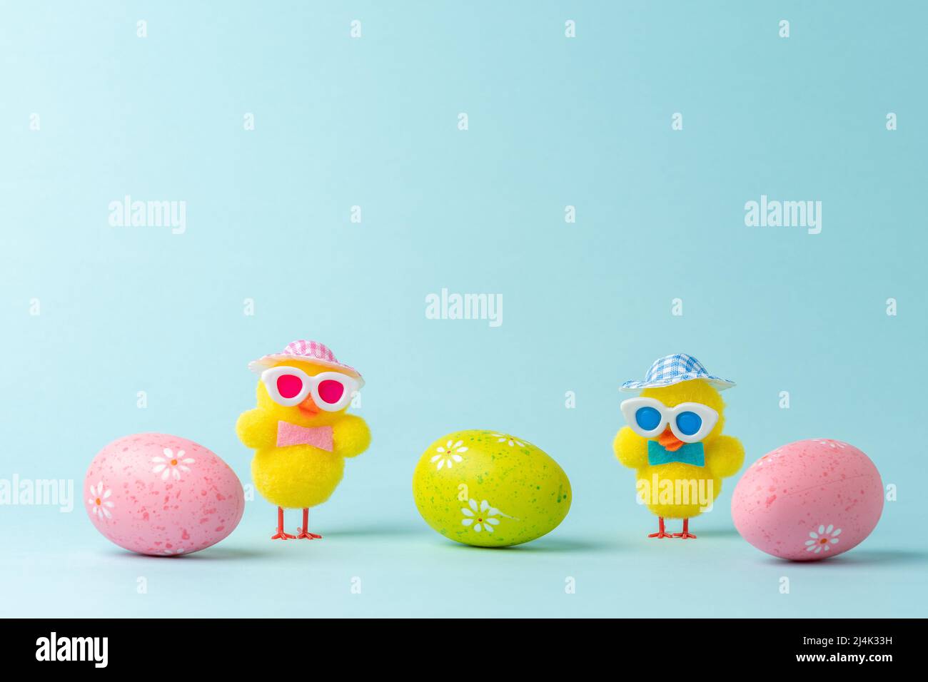 Funny chicken dolls with colorful Easter eggs. Minimal Easter concept. Stock Photo