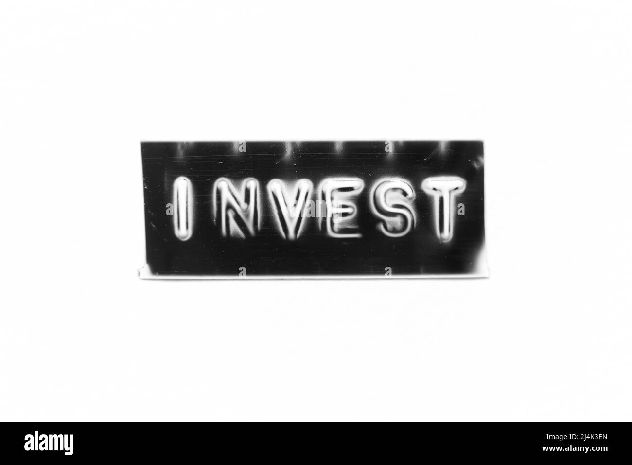 Black color banner that have embossed letter with word invest on white paper background Stock Photo
