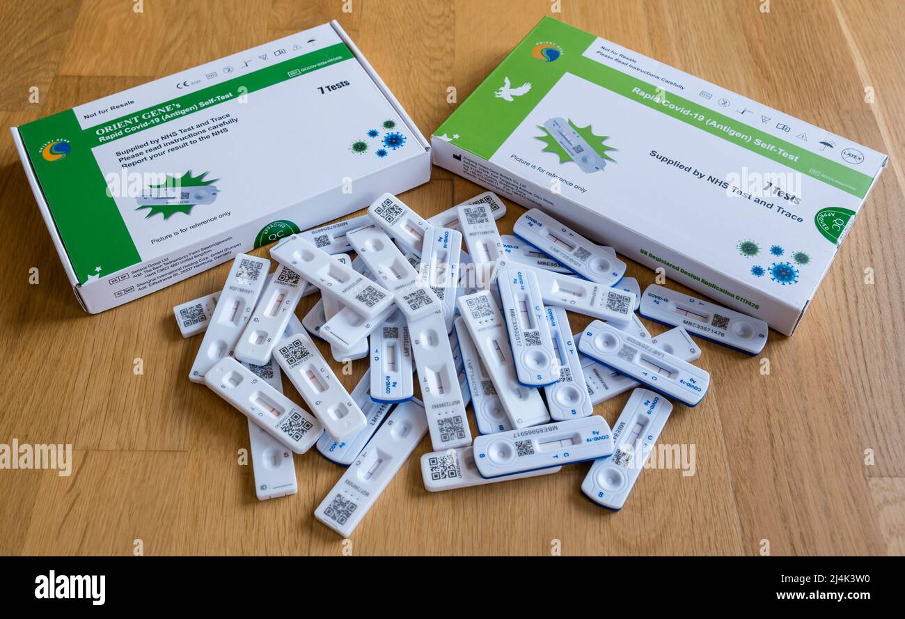Covid-19 or coronavirus rapid antigen self-testing packs or kits and a pile of negative lateral flow test sticks during the pandemic Stock Photo