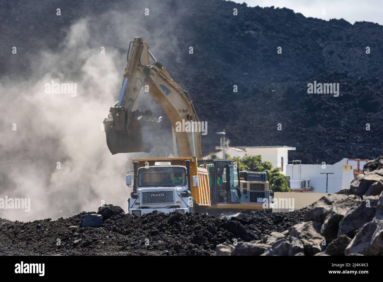 La Palma Island Spain - March 03, 2022: Crane and truck cleaning the way covered with lava after the Cumbre Vieja volcanic eruption Stock Photo