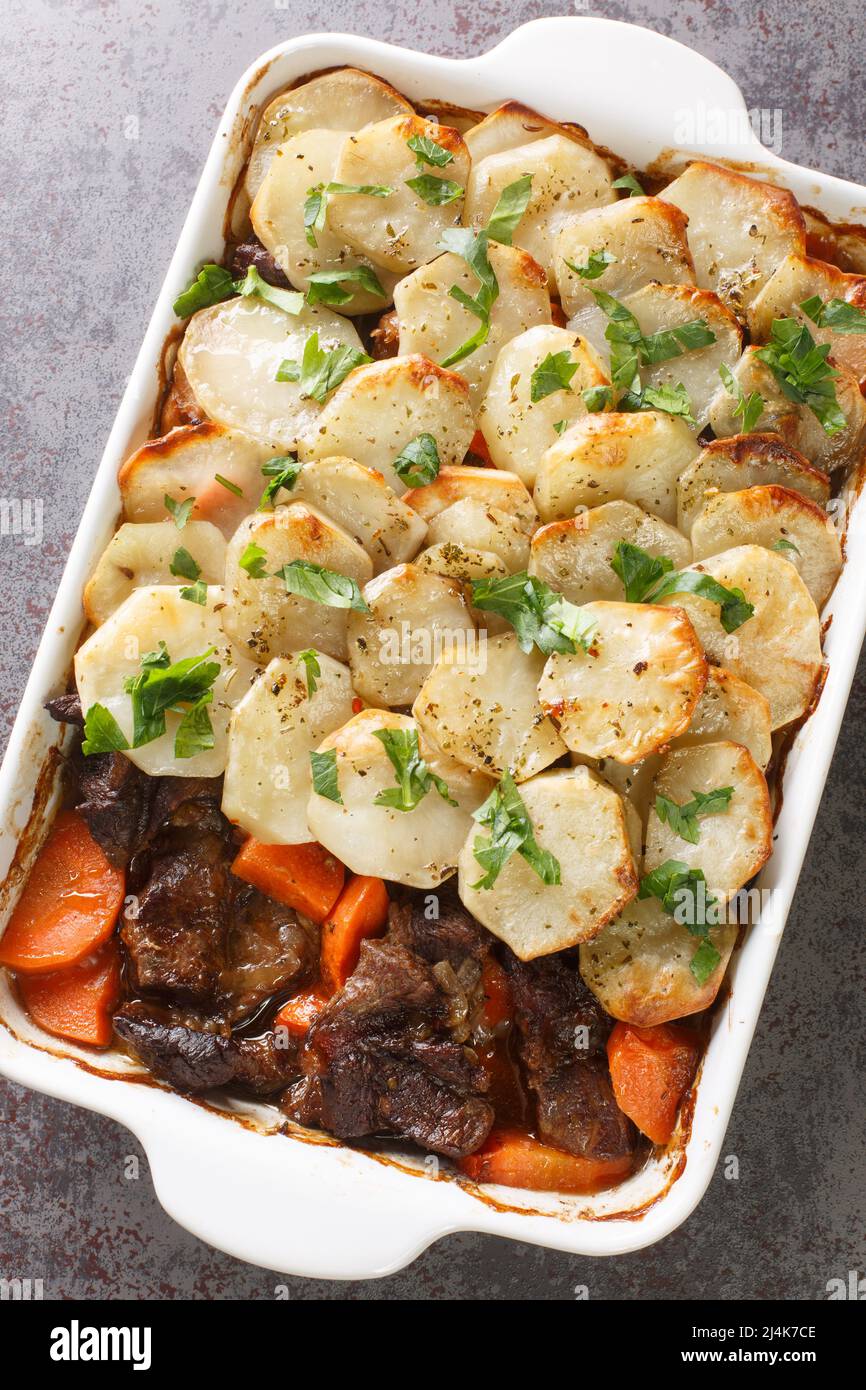 Lancashire Hotpot Succulent lamb in a meaty gravy, topped with potatoes that are tender underneath and crisp on top closeup in the baking dish on the Stock Photo