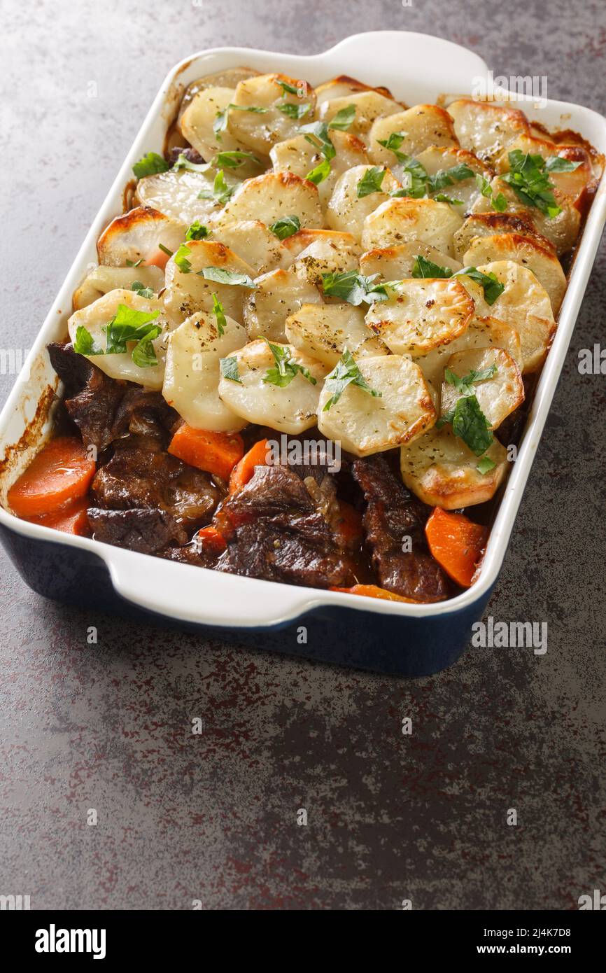 Homemade Lancashire hotpot a stew consists of lamb, onion, carrot, Worcestershire sauce, topped with sliced potatoes closeup in the baking dish on the Stock Photo