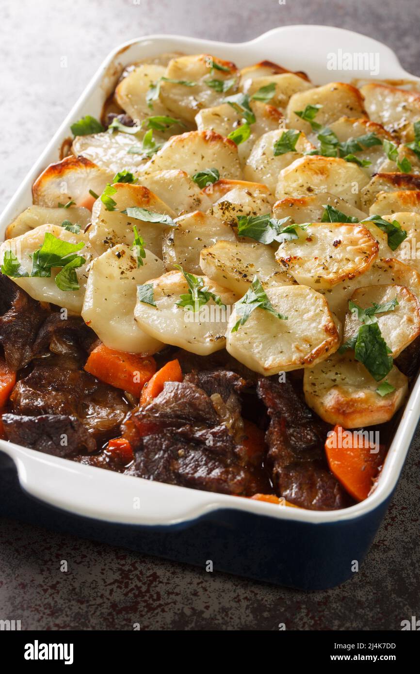 Lancashire Hotpot Succulent lamb in a meaty gravy, topped with potatoes that are tender underneath and crisp on top closeup in the baking dish on the Stock Photo