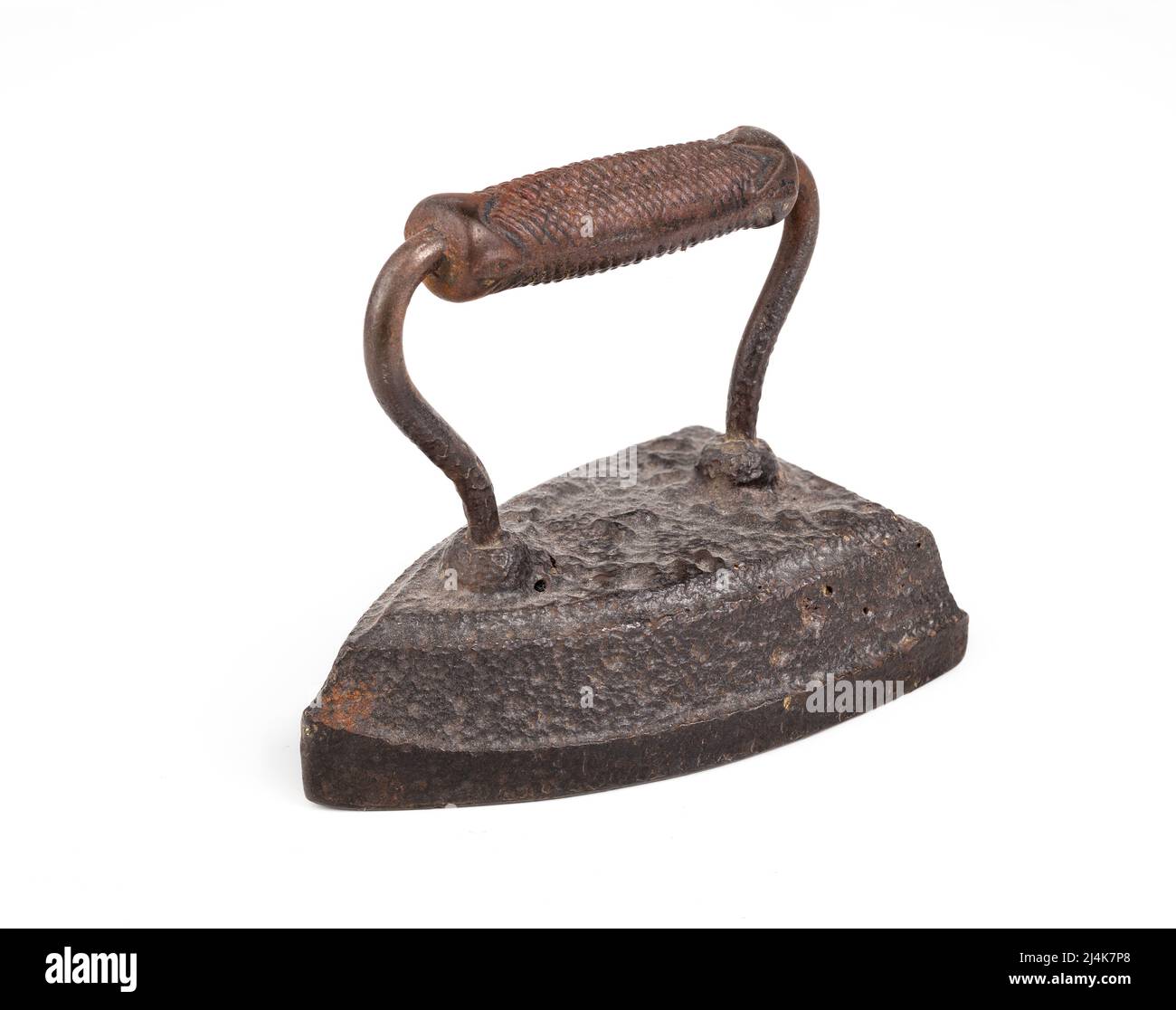 Isolated antique flat iron, perspective view. Vintage flat iron or sad iron made of cast iron with handle. Heated up in can be used to press cloth Stock Photo