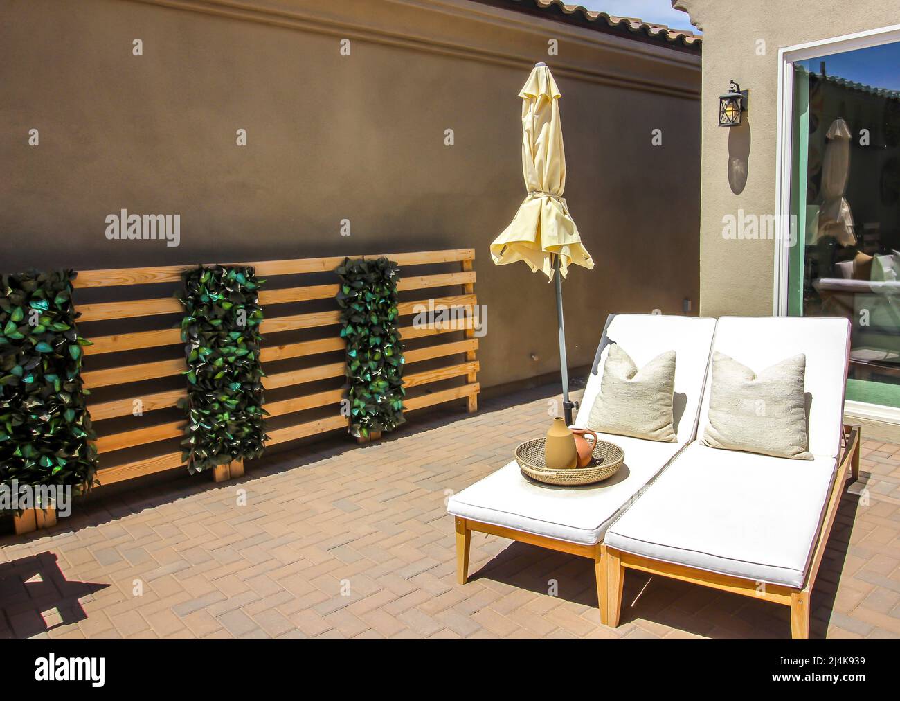 Two Adjustable Lounge Chairs With Umbrella On Rear Patio Stock Photo